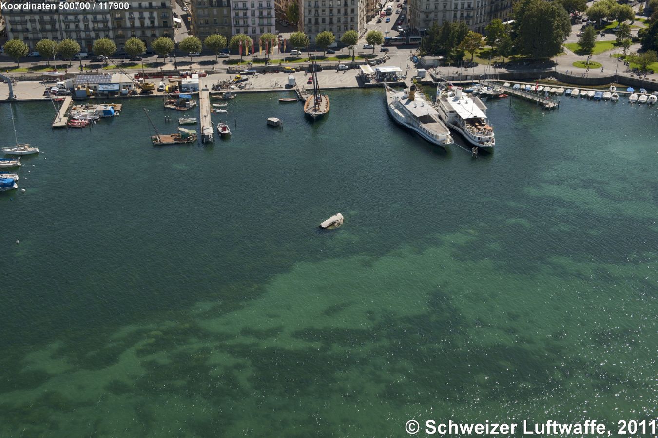 Genf / Genève, Pierres du Niton, 373,6 M.ü.M., (Position 2'500'876.10, 1'117'944.70), Blickrichtung Süd zum Quai Gustave-Ador. Ganz rechts oben im Bild: Jardin Anglais. - Der Repère Pierre du Niton, kurz RPN, ist der auf einem Felsen im Hafen von Genf angebrachte Referenzpunkt («repère») der Höhenmessung in der Schweiz und in Liechtenstein. Es handelt sich um zwei erratische Granitblöcke aus dem Mont Blanc.